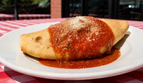 Panzerotto topped with tomato sauce and Parmesan